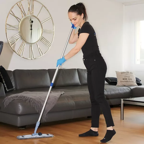 Reinigungsfachkraft von Ever-Clean in Zürich wischt den Holzboden für den Home Hotel Service mit einem Mopp.