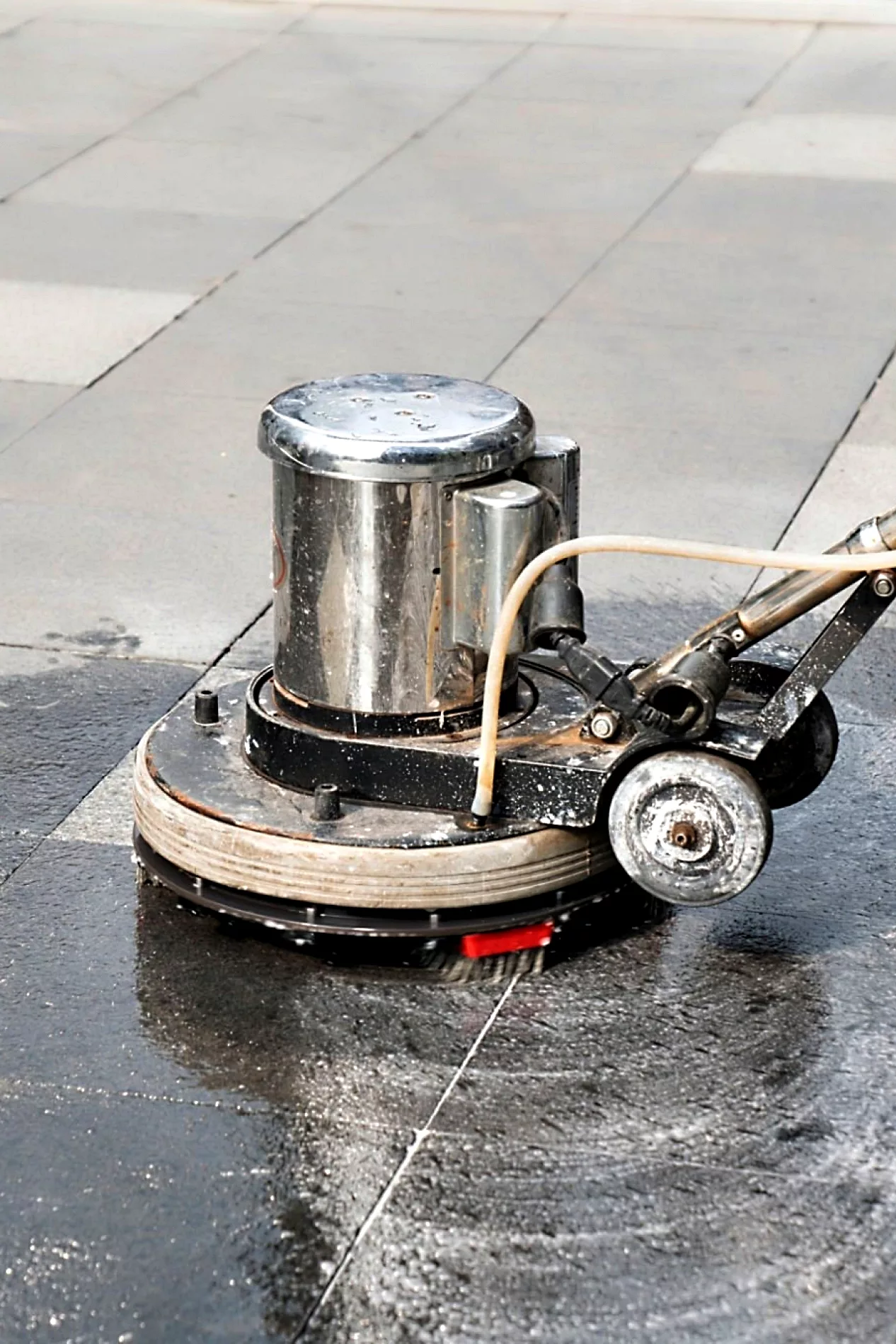 Die Profis reinigen und waschen den Außengehweg mit der Poliermaschine.